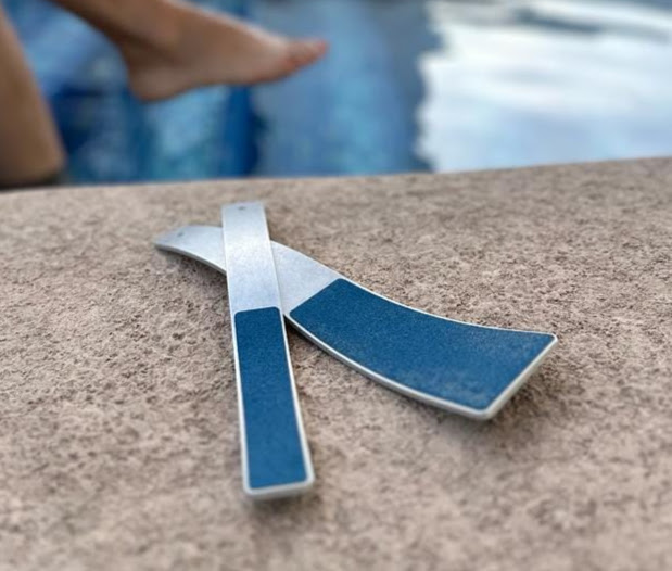 A pair of blue and white plastic strips on the side of a pool.